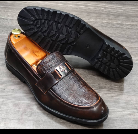 This is a nice pair of black shoes. It is unique and comes unique. Made up of golden metals at the top. This shoe makes one looks attractive and presentable for any occasions. It can be used for office and any other celebrations one plan to attend. The soles are very strong and solid and it has a round front and the inside leather is brown. Available size 40 - 45.