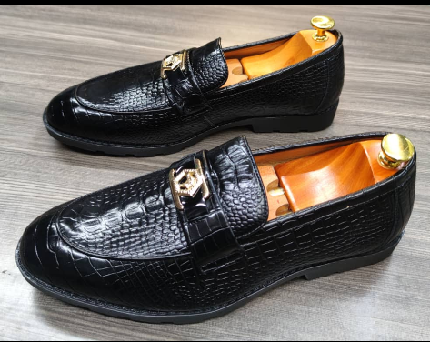 This is an outstanding pair of black shoes. It is unique and comes unique. Made up of golden objects at the top and on the sides. This shoe makes one looks attractive and presentable for any occasions. It can be used for office and any other celebrations one plan to attend. The soles are very strong and solid and it has a round front and the leather is brown. Available size 43 - 44.
