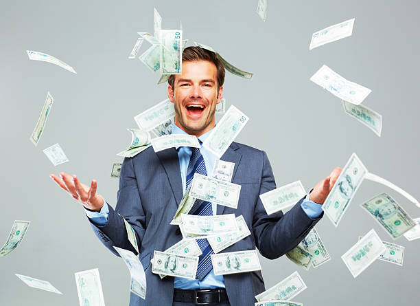 Studio shot of a well dressed man tossing money up in the air around him